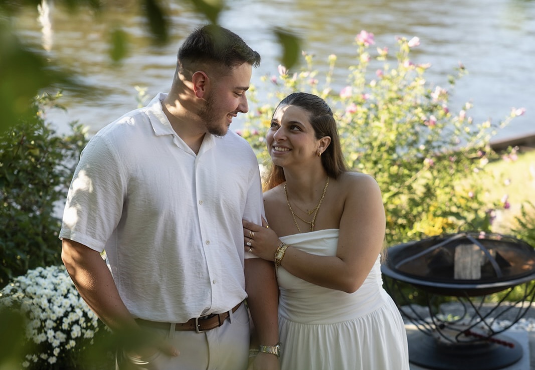 Andrew and Laura smiling at each other by the water